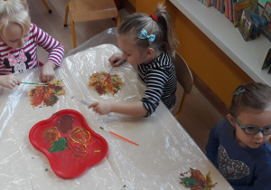 Dzieci malują liść farbami