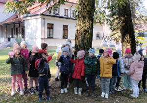Dzieci stoją całą grupa prze leśniczówką