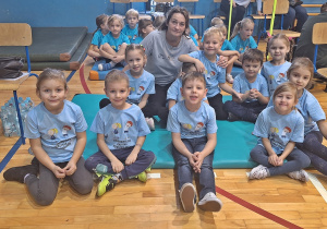 Dzieci z wychowawczynią oczekują na rozpoczęcie Igrzysk Przedszkolaków