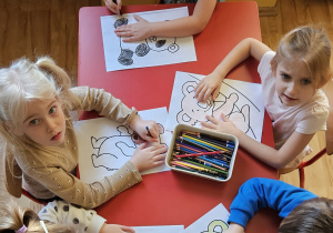 Dzieci kolorują rysunek misia