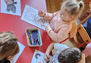 Dzieci kolorują rysunek misia