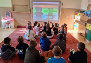 Dzieci oglądają fim i poznają historię pluszowego misia