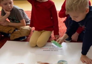 Chłopiec przylepia sałatę na narysowanym na plakacie talerzu