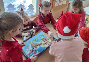 Dziewczynki rozpakowują prezent od Mikołaja - klocki lego