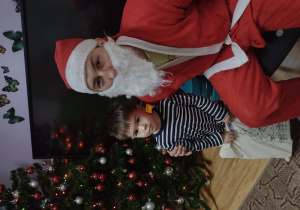 Chłopiec pozuje do zdjęcia z Mikołajem