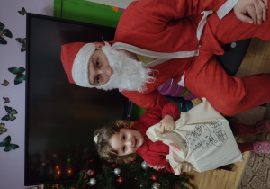 Dziewczynka pozuje do zdjęcia z Mikołajem