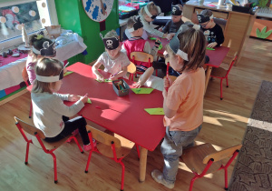 Dzieci kolorują papierowe statki mazakami