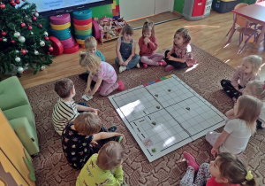 Dzieci grają w grę z ęlementami kodowania "Głodna żyrafa"