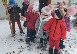 Dzieci spacerują w ogrodzie w zimowej aurze