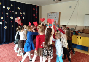 Dzieci tańczą taniec z sercami z kartonu