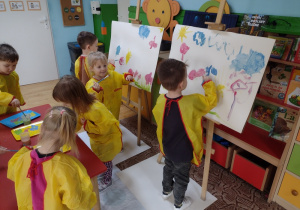 Dzieci malują obrazy na sztaludze