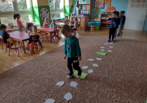 Dzieci bawią się w zabawę ruchową "Śladem dinozaurów"