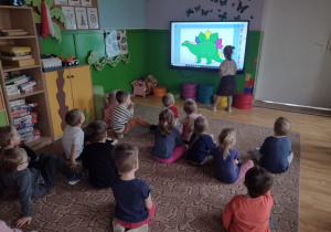 Dzieci kolorują multimedialną kolorowankę dinozaura