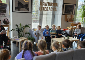 Członkini Klubu Literackiego Topola czyta dzieciom opowiadanie