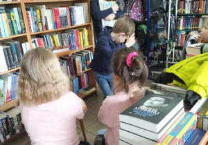 Dzieci słuchają opowiadania Pani pracującej w księgarni