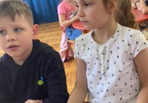 Dziewczynka zaznacza kredką godzinę na zegarze