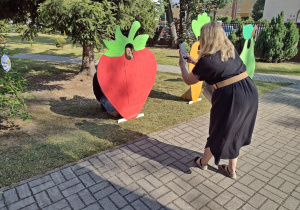 Kobieta robi zdjecie dziecku w alei fotobudek