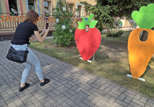 Kobieta robi zdjecie dziecku w alei fotobudek