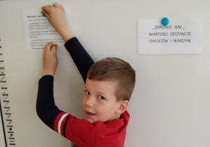 Chłopiec tworzy elementy gazetki o zdrowym żywieniu