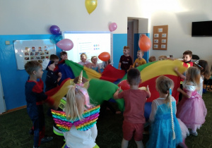 Przedszkolaki uczestnicza w zabawie z chusta animacyjna i balonami