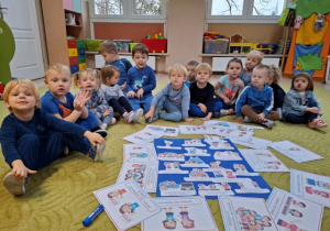 Dzieci siedzą przed plakatem
