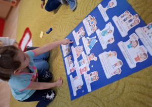 Dziewczynka odbija palec na plakacie