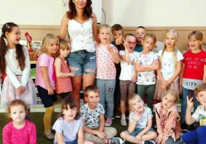 Dzieci pozują do zdjęcia z zaproszonym gościem