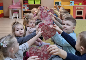 Dzieci w parach unoszą serca do góry