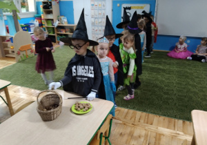 Chłopiec wkłada do koszyczka dary