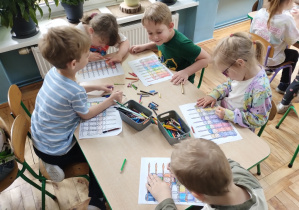 Dzieci kolorują karty pracy