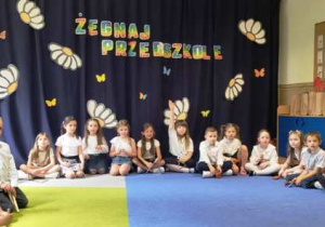 Dzieci siedzą w półokręgu