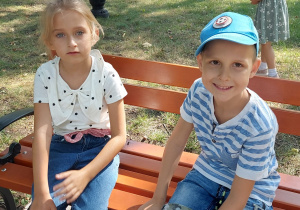 Dzieci siedzą na ławce w parku