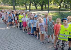 Dzieci stoją ustawione parami w parku