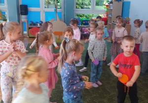 Dzieci chodzą po dywanie w sali przedszkolnej
