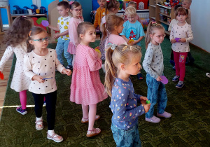 Dzieci chodzą po dywanie w sali przedszkolnej