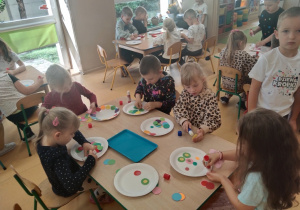 Dzieci wykonują kolorowe kompozycje z kolorowych kół