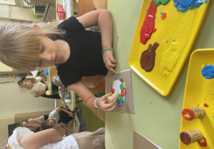 Dziewczynka stempluje kropkę.