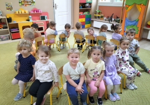 Dzieci siedzą na krzesełkach