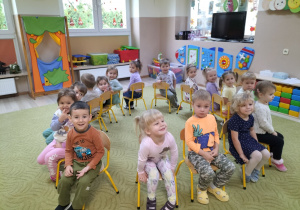 Dzieci siedzą na krzesełkach