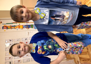 Chłopcy uśmiechają się do zdjęcia.