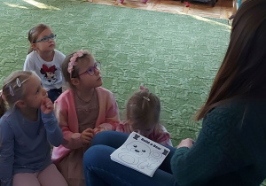 Dzieci słuchają czytanego przez panią psycholog opowiadania