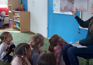 Dzieci słuchają czytanego przez panią psycholog opowiadania