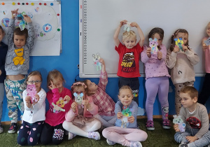 Dzieci pozują do zdjęcia trzymając misie wycięte z papieru