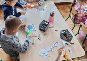Dzieci wycinają misia z papieru