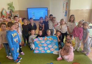 Dzieci pozują do zdjęcia z plakatem