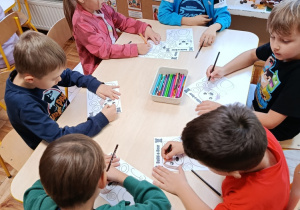 Dzieci na zajęciach z psychologiem kolorują misia