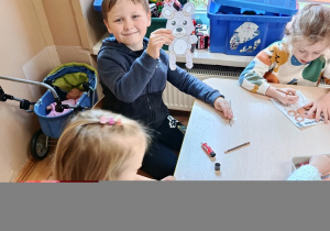 Dzieci na zajęciach z psychologiem kolorują misia