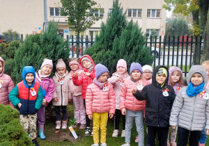 Dzieci pozują do zdjęcia w ogrodzie przedszkolnym
