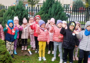 Dzieci pozują do zdjęcia w ogrodzie przedszkolnym