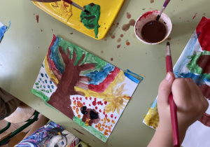 Dzieci malują drzewa.